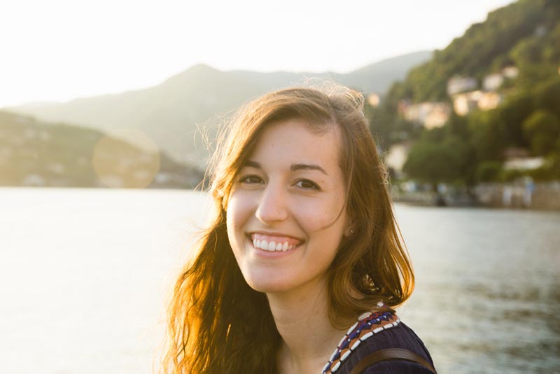 young woman smiling and happy by lake