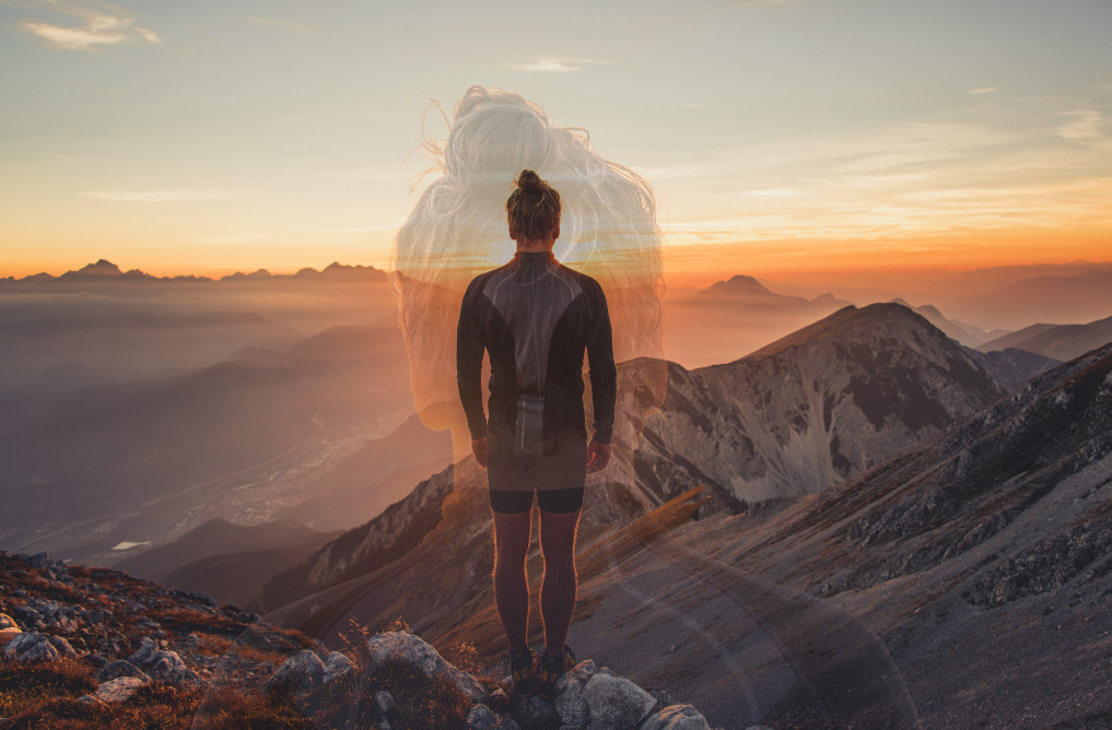 Male hiker observing the sunset at the top of the local big mountain after psychedelic treatment